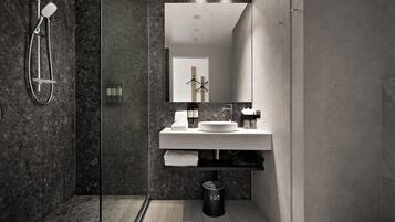 A modern bathroom with a glass-enclosed shower, a white sink, and a mirror above it.