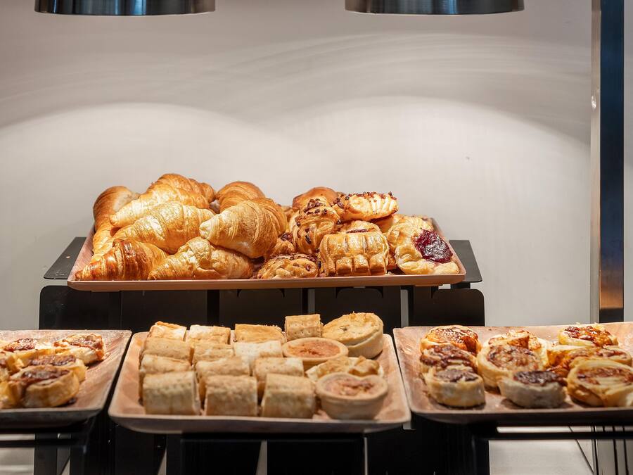 A variety of baked goods displayed on trays in a commercial setting.