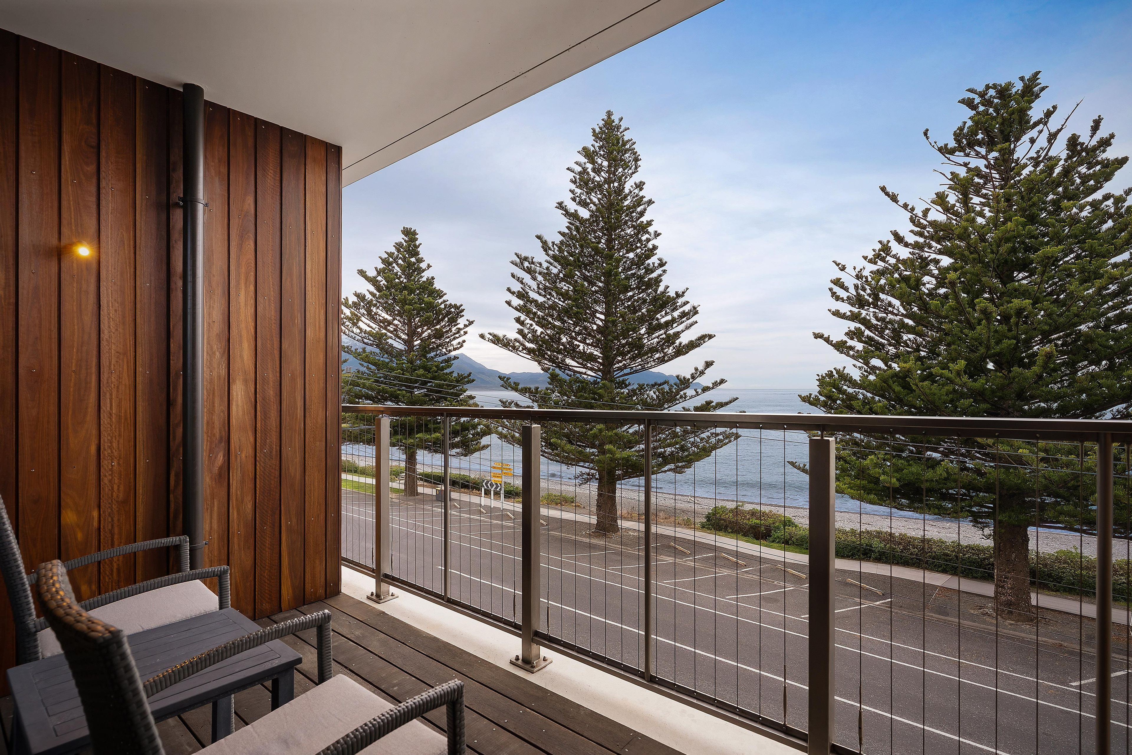 Ein Balkon mit Blick auf das Meer und Bäume.