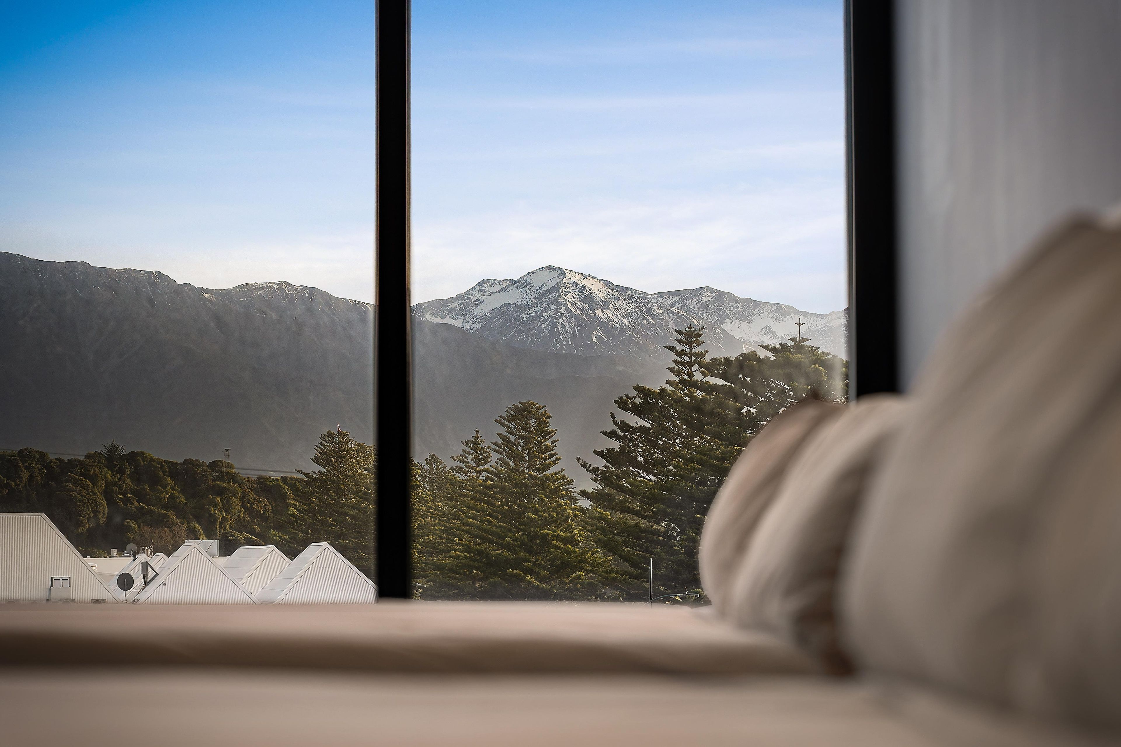 A room with a view of snow-capped mountains through a window.
