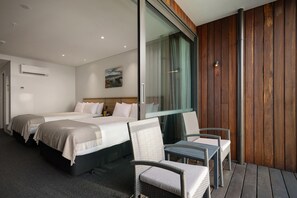 A hotel room with two beds, a large window, and a seating area with chairs. - Sudima Kaikoura (Kaikoura)