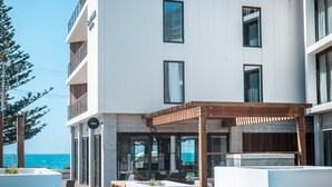 Un hôtel moderne doté d’une piscine, d’un espace extérieur aménagé et offrant une vue sur l’océan.