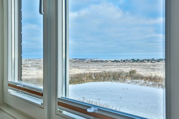 A view through a window of a snowy landscape with a clear sky.