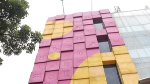 A building facade with a large, colorful zodiac sign mural. - Best Hotel (Surabaya)