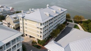 A multi-story hotel with a flat roof, large windows, and a view of the water.