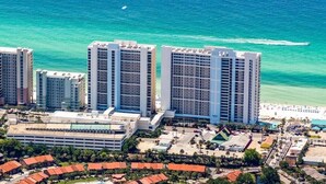 Un hotel de gran altura con varios pisos, estacionamiento y vistas a la playa.