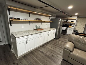 A modern kitchen with white cabinets, a granite countertop, and stainless steel appliances.