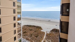 A high-rise building with multiple balconies overlooking a beach. - Oceanfront Condo-large, corner balcony, enclosed pool in popular Cherry Grove Beach (North Myrtle Beach)