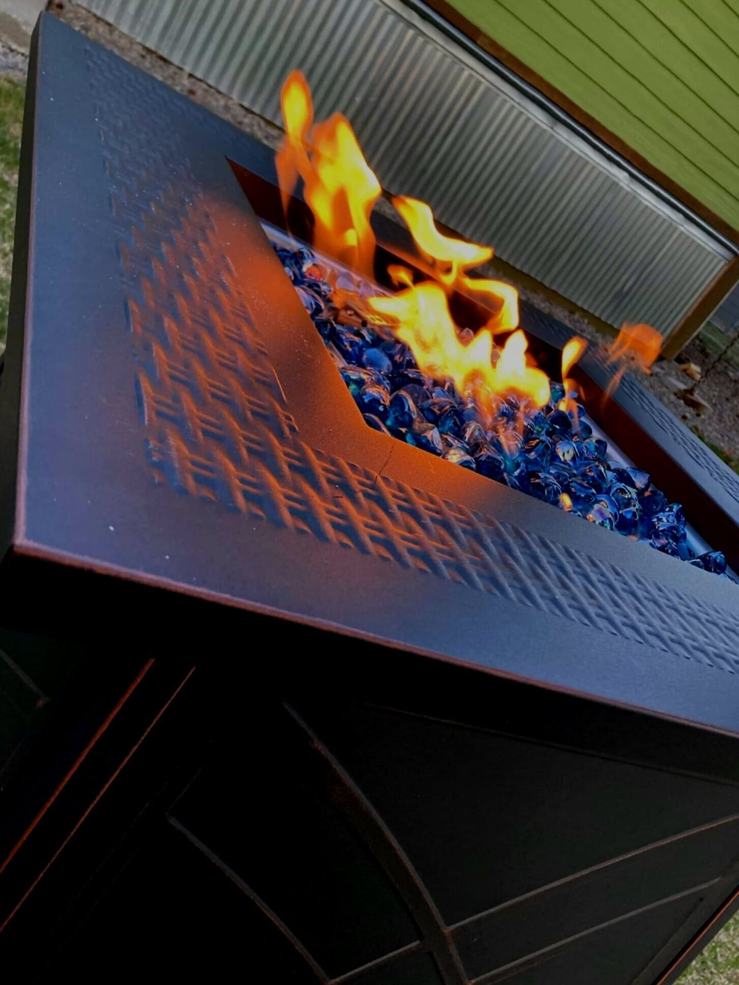 Ein Metall-Feuerkorb mit glühender Holzkohle und Flammen.