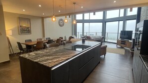 A spacious kitchen with a large island, pendant lighting, and a view through large windows. - Pendle View Sleeps 8 with Hot Tub (Longridge, Preston)