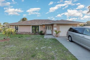 Single-story house with a well-maintained lawn and a driveway.