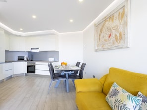 A modern apartment with a kitchen, dining area, and living room.