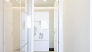 A hallway with a glass door leading to a room with a leaf-patterned wall and a tiled floor. - Beautiful Vacation Home with Sea Views in the Ocean Garden Complex (Adeje)