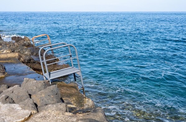 A rocky shoreline with a metal ladder leading into the water. - Beautiful Vacation Home with Sea Views in the Ocean Garden Complex (Adeje)
