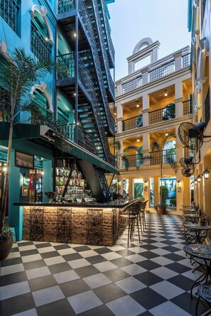 A multi-level atrium with a checkered floor, a bar area, and outdoor seating. - Quba by Montraj Pattaya, previously The Quba Hotel Pattaya (Pattaya)