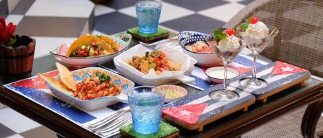 A table set with various dishes, drinks, and a decorative centerpiece.