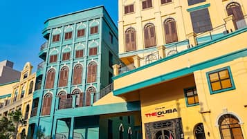 A hotel with a teal facade and a yellow building adjacent to it.