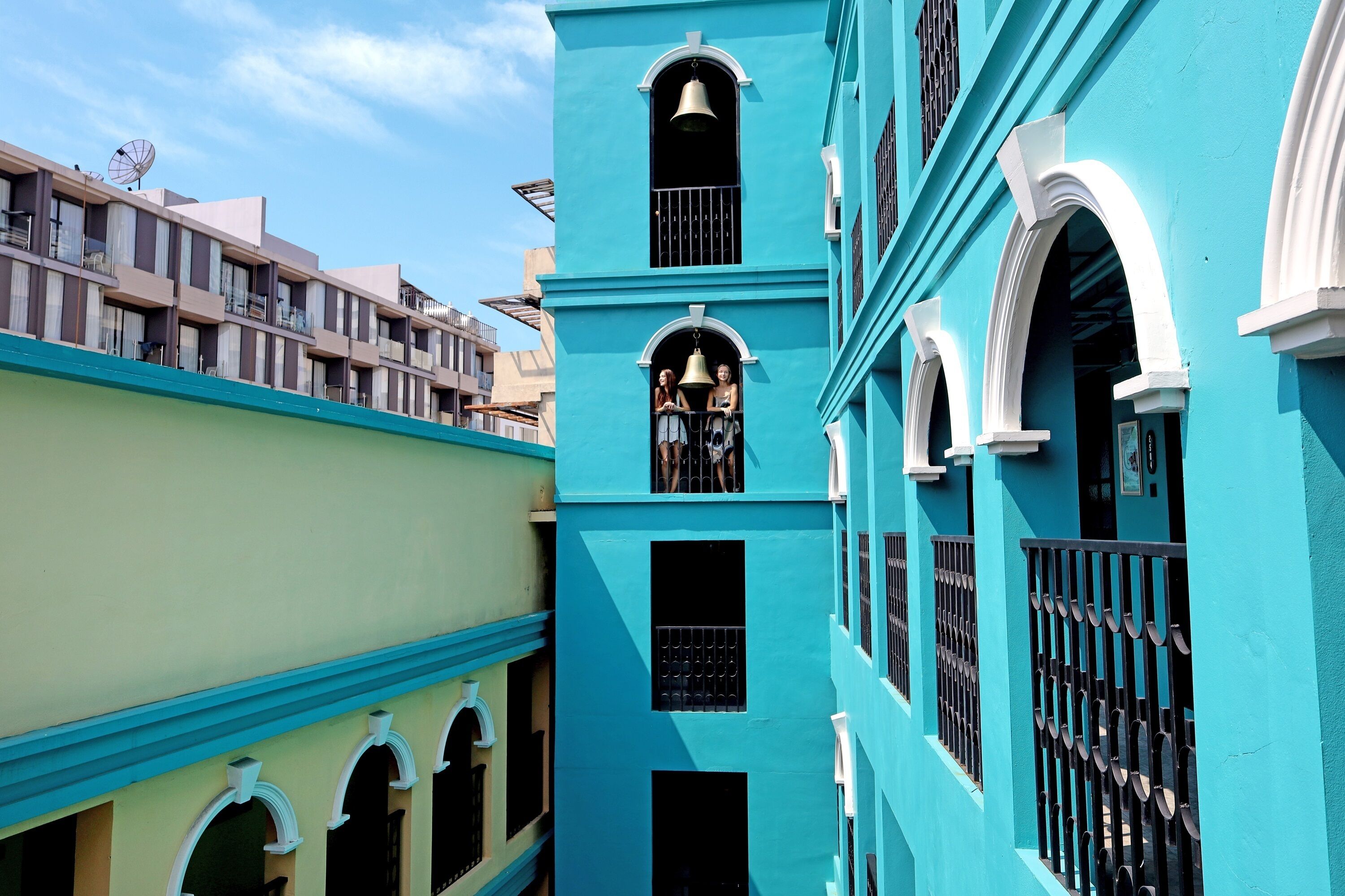 A multi-story building with balconies and arched windows.