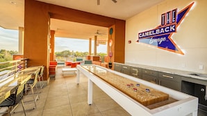 A camelback lounge with a shuffleboard table, seating area, and a view of the outdoors. - Scottsdale Condo - Great Location, Pool, Full Kitchen (Scottsdale)