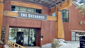 Een houten gebouw met een bord waarop ‘THE EXCHANGE’ staat.