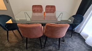 Une table de conférence avec un plateau en verre et quatre chaises, deux de chaque côté.
