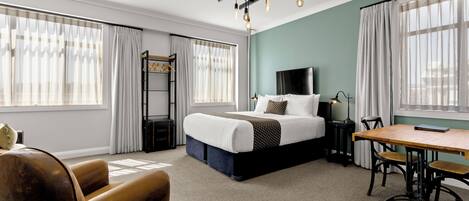 Una habitación de hotel moderna con una cama grande, un escritorio y una silla.