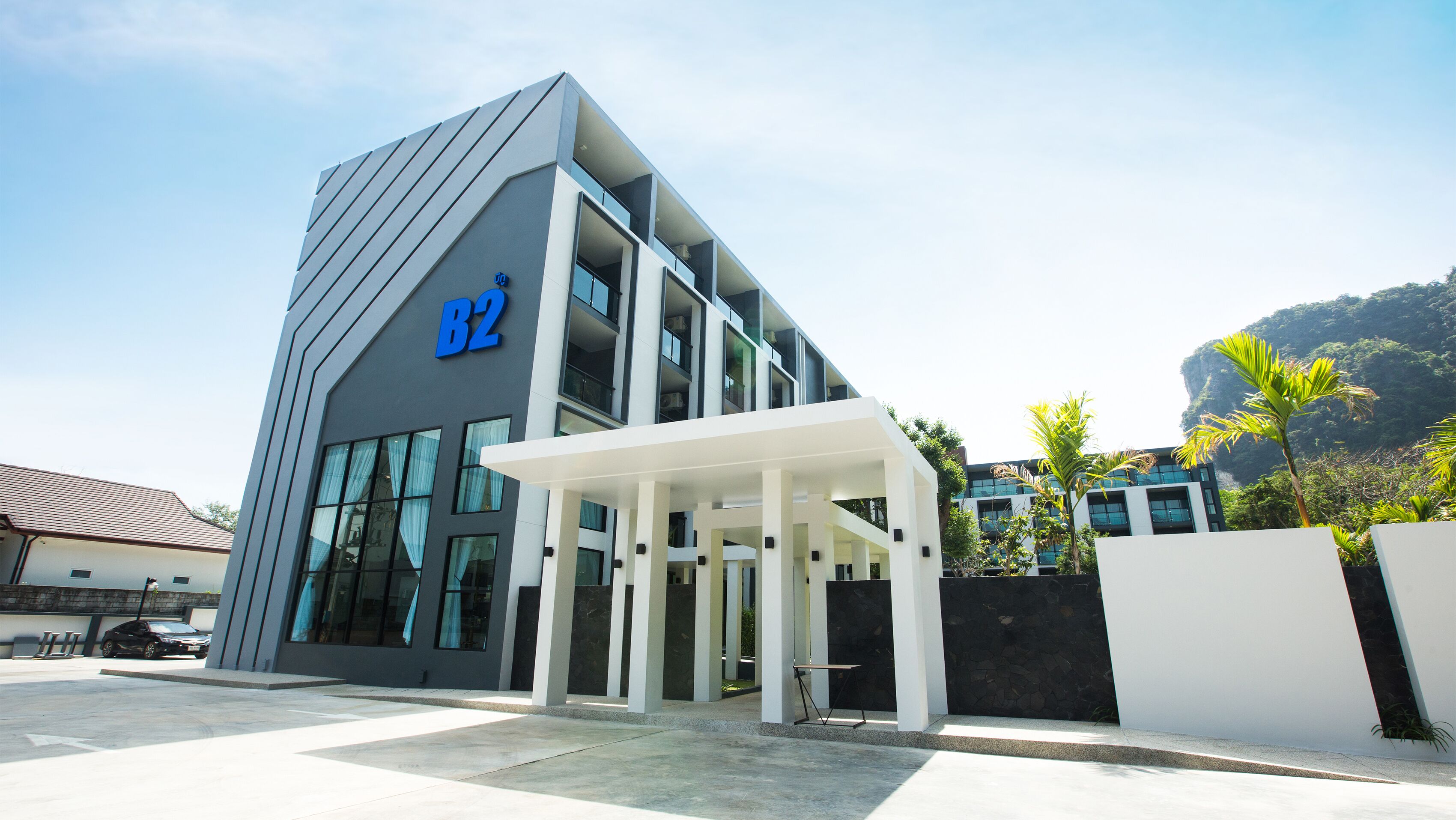 A modern building with a prominent 'B2' sign, large windows, and a covered entrance area.