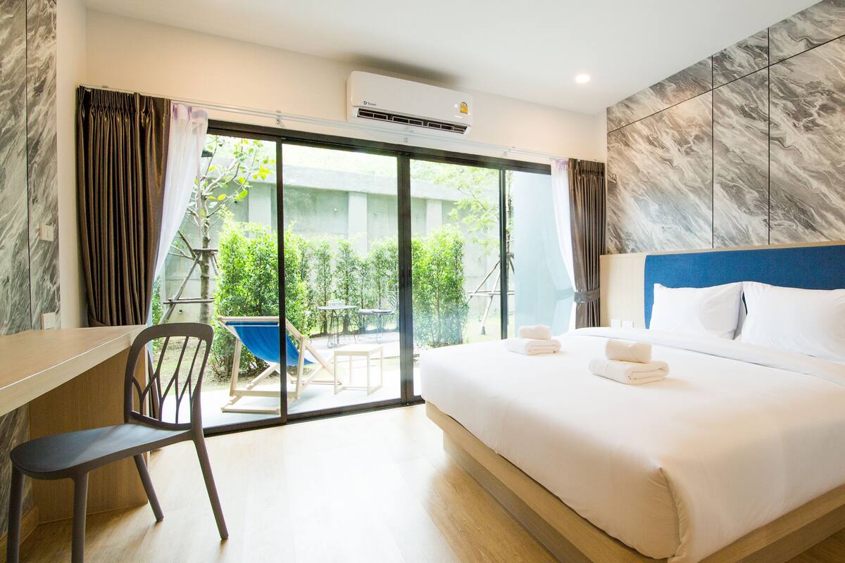 Habitación de hotel con una cama, un escritorio, una silla y vistas al exterior.