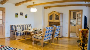 Un salon chaleureux avec un plancher en bois, un canapé, une table à manger et un buffet.