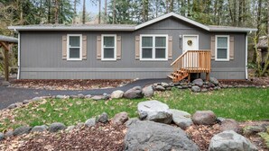 A two-story house with a front porch, a small staircase, and a rock garden. - Newly Constructed, Single Level, Open Layout, Walk to Sandy River, 17 Miles to Government Camp (Rhododendron)