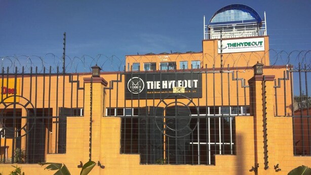 A building with a sign that reads "THE HYDEOUT" and another sign above it that says "THE HYDEOUT". - The Hydeout Riviera (Kisumu)