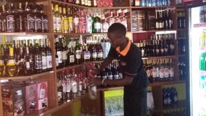 A bar area with shelves stocked with various liquor bottles and glasses. - The Hydeout Riviera (Kisumu)