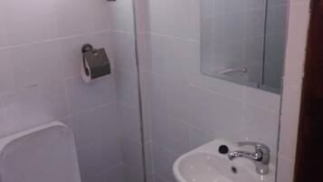 Een bad/douchecombinatie, handdoeken