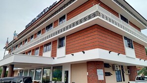 Un hotel de varios pisos con fachada de ladrillo, balcones y una zona de estar exterior cubierta.