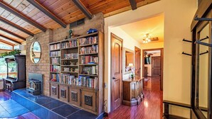 A spacious living area with a large bookshelf, a fireplace, and a stone wall.