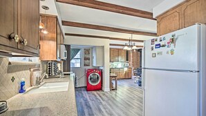 A modern kitchen with wooden cabinets, a built-in washing machine, and a refrigerator. - Quaint La Mesa Home with Beautiful Sunsets! (La Mesa)
