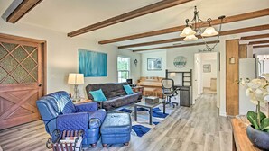 A spacious living room with a sectional sofa, a coffee table, and a piano in the background. - Quaint La Mesa Home with Beautiful Sunsets! (La Mesa)