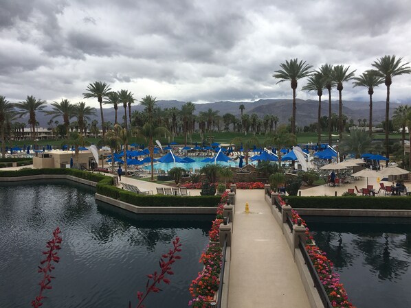 A resort pool area with multiple pools, lounge chairs, and umbrellas.