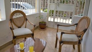 A room with two wicker chairs and a table with two glasses of orange juice. - North Manor Nakuru (Nakuru)