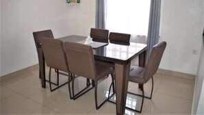 A dining area with a rectangular table and four chairs. - North Manor Nakuru (Nakuru)