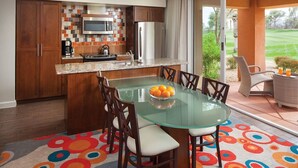 A modern kitchen with a glass dining table, wooden cabinets, and a colorful backsplash. - Marriott's Shadow Ridge - Enclaves - 2 Bedroom (Palm Desert)
