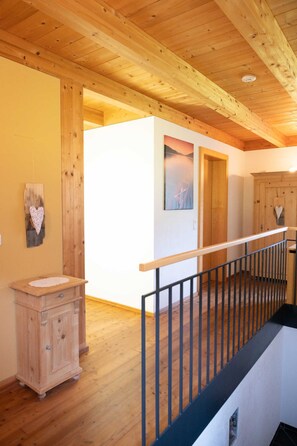 A wooden interior with a wooden cabinet, a white wall, and a wooden door.