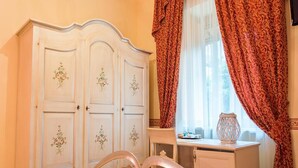 A bedroom with a bed, a dresser, and a window with curtains. - Belvilla by OYO Villa Martina (Agropoli)