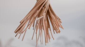 A close-up of a bundle of thin, light brown sticks tied together.