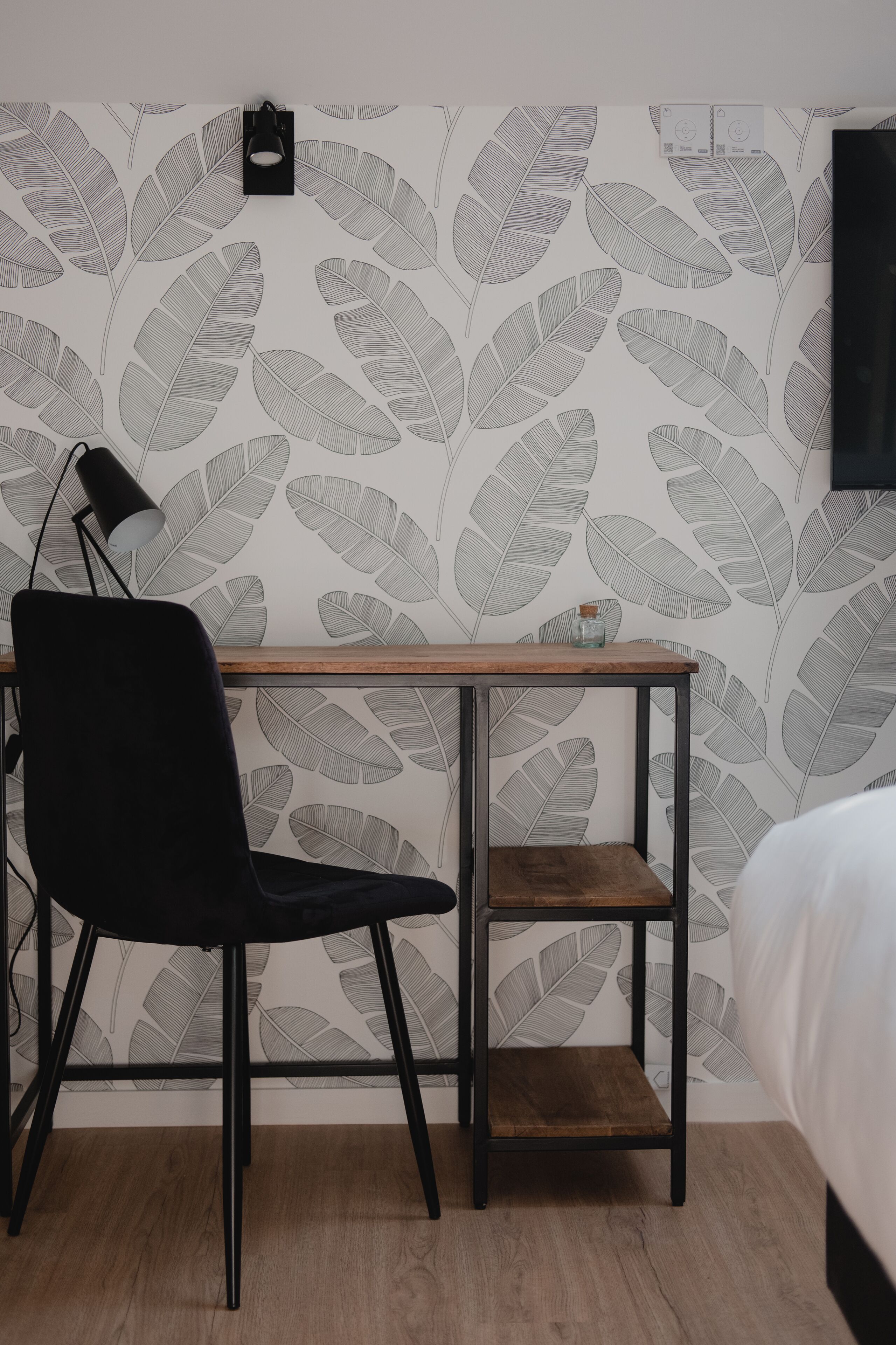 Een kamer met een bureau, stoel en bed.