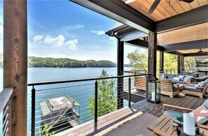 Une terrasse avec des sièges extérieurs donnant sur un lac.