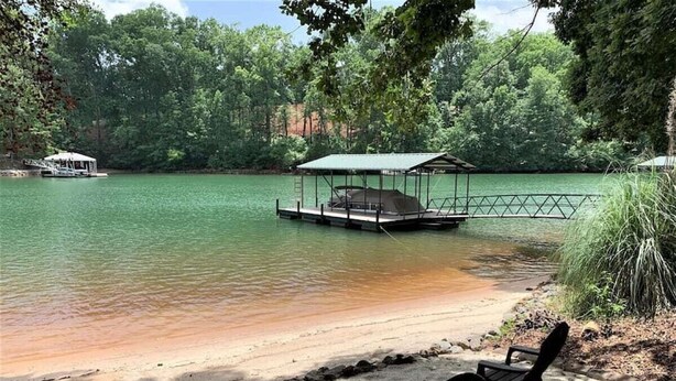 Un cadre idyllique au bord du lac, avec un quai, des chaises et un espace abrité.