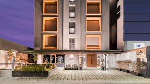 A modern hotel with a central entrance, multiple balconies, and a well-lit facade. - Aspira Parc Sukhumvit 22 (Bangkok)