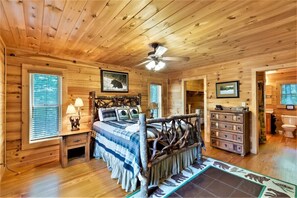 A wooden cabin bedroom with a bed, nightstands, a dresser, and a ceiling fan. - Massive Lake Keowee Knox Campground Cabin (Seneca)