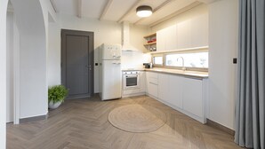 Een moderne keuken met witte kasten, een inbouwoven en een koelkast.